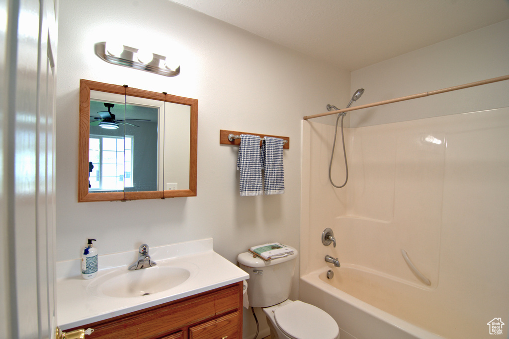 Full bathroom with toilet, ceiling fan, vanity, and washtub / shower combination