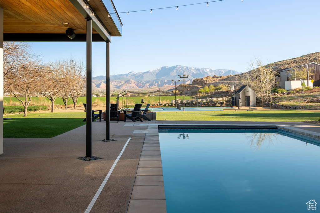 View of swimming pool with a mountain view, a yard, and an outdoor structure