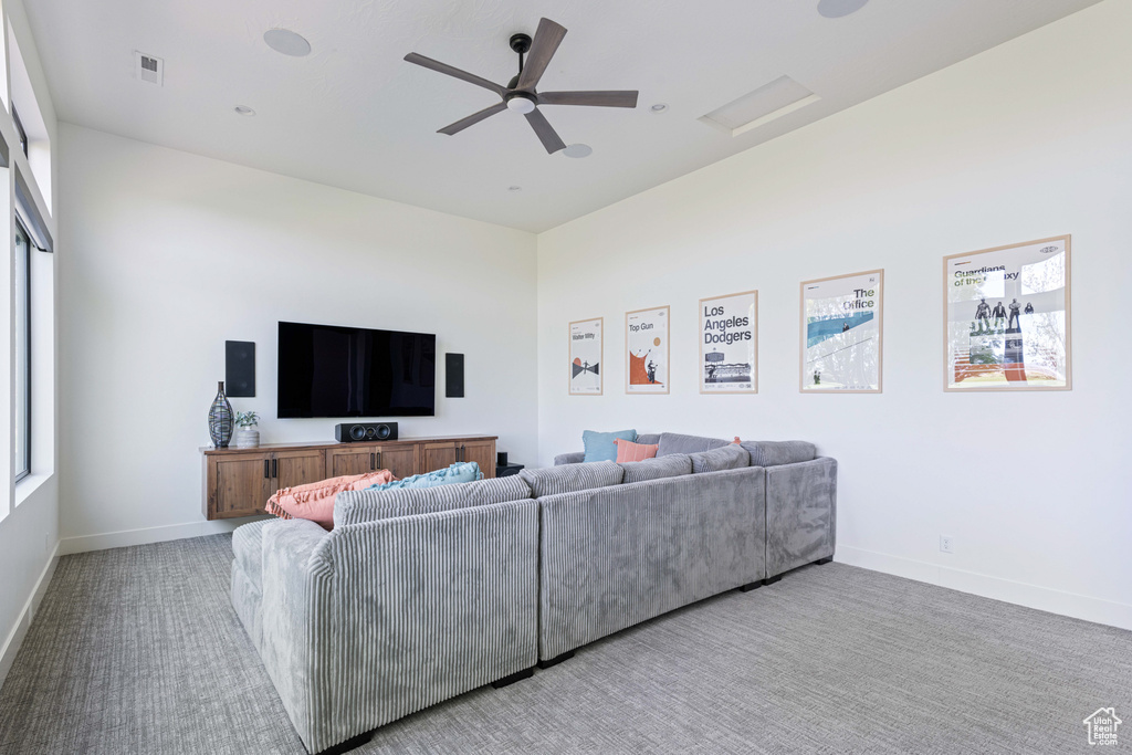 Carpeted living room with ceiling fan
