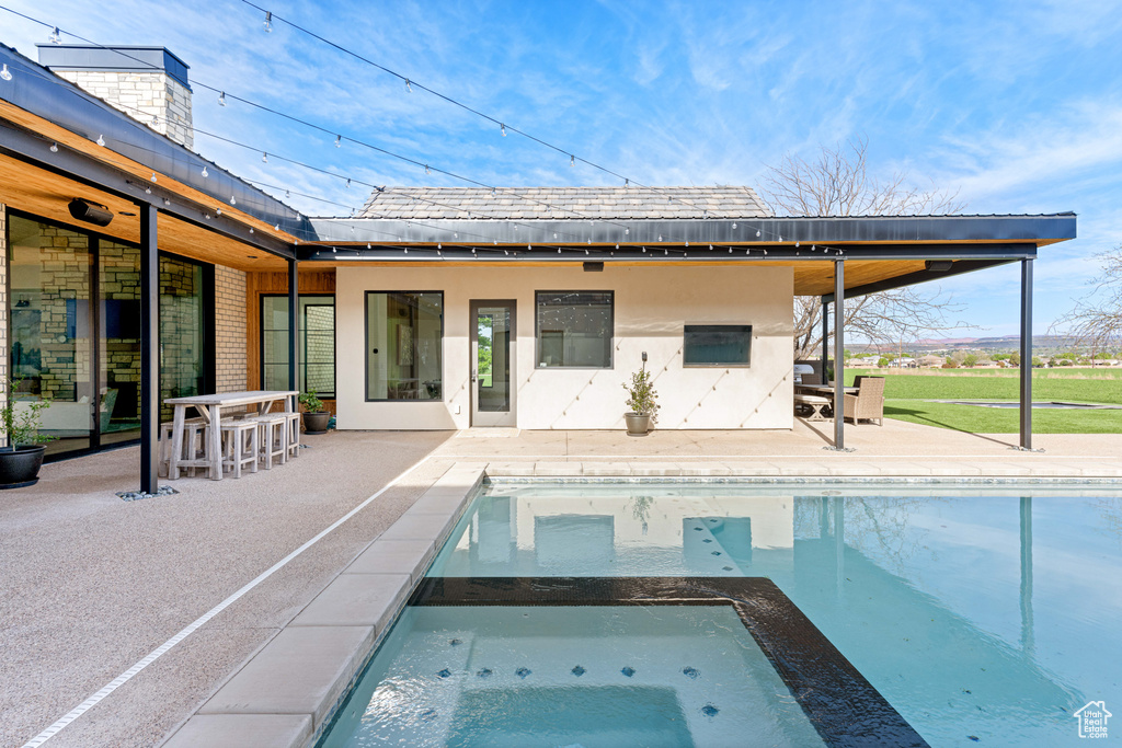 View of swimming pool featuring a patio area and an in ground hot tub