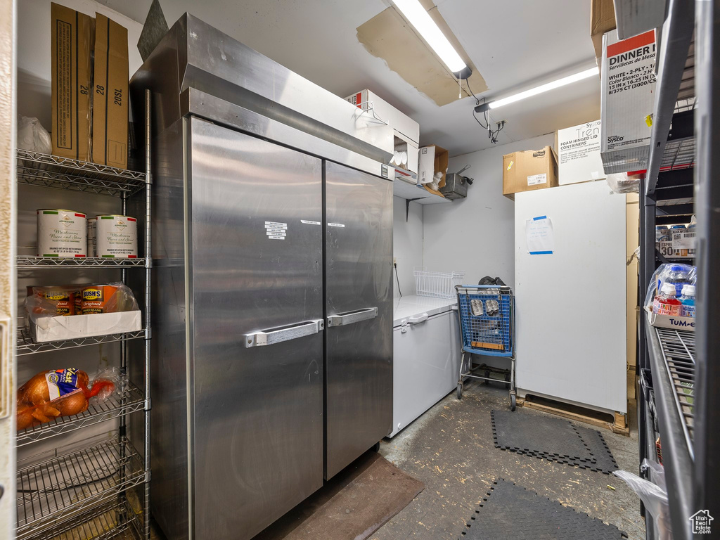 Kitchen with white fridge and stainless steel built in refrigerator
