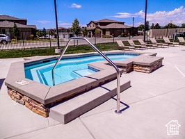 View of swimming pool featuring a hot tub and a patio