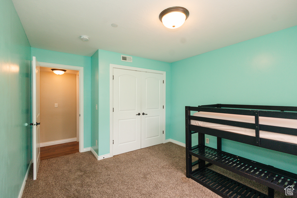 Bedroom featuring carpet flooring and a closet