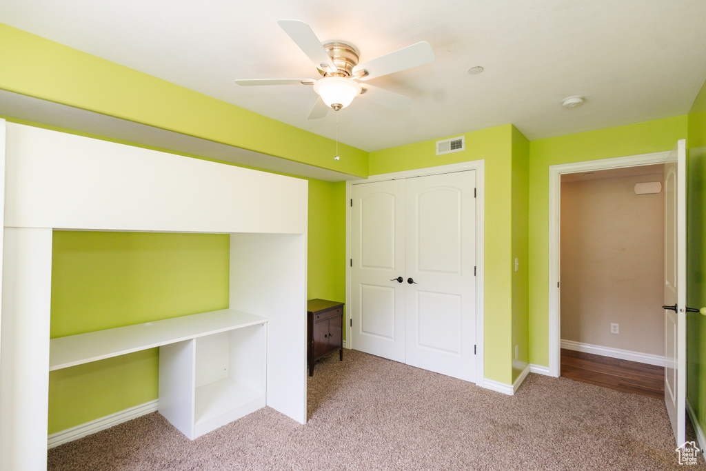 Unfurnished bedroom with carpet, ceiling fan, and a closet