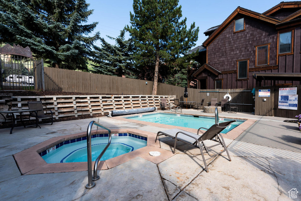 View of pool with a patio area and a community hot tub