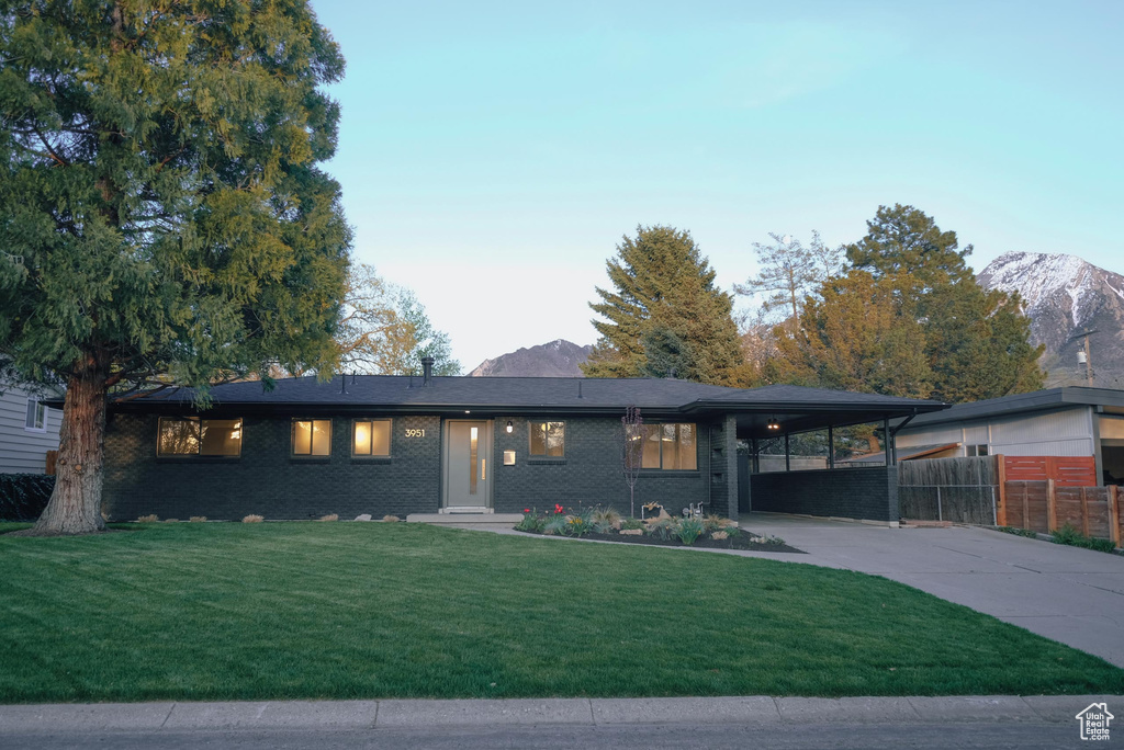 Prairie-style home featuring a carport, a mountain view, and a front lawn