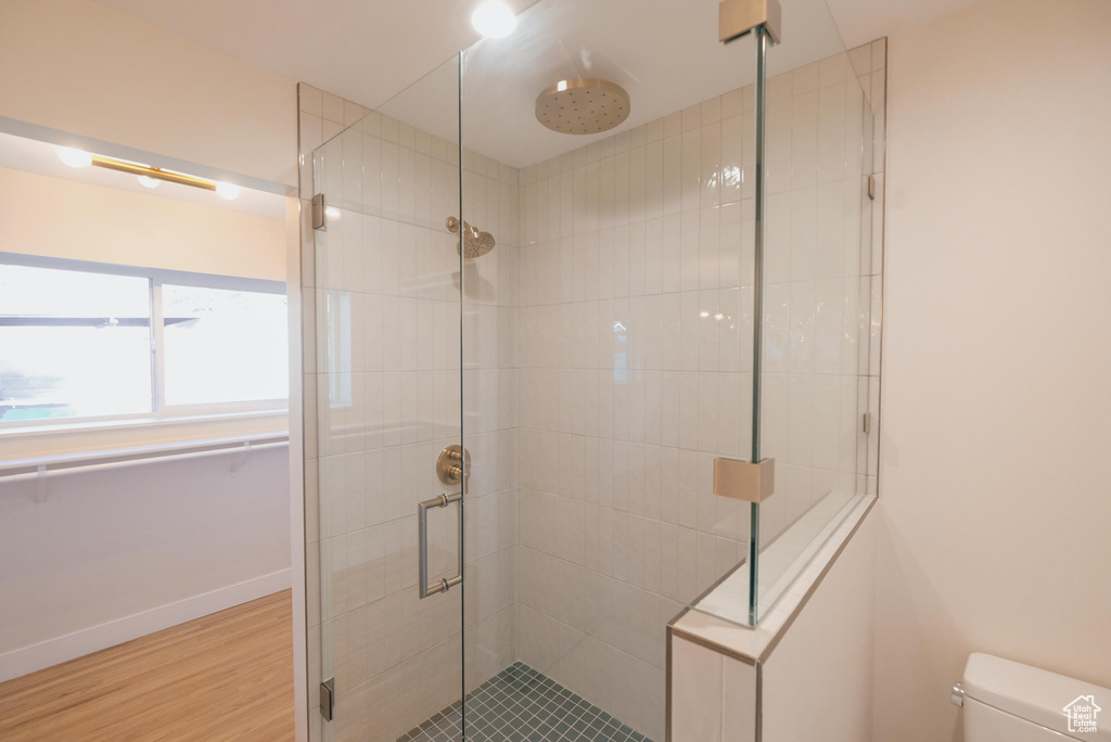 Bathroom featuring hardwood / wood-style floors, walk in shower, and toilet
