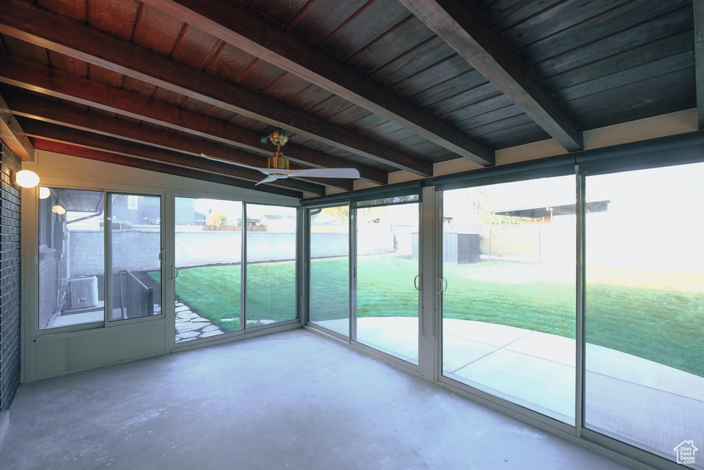 Unfurnished sunroom with lofted ceiling with beams and wood ceiling