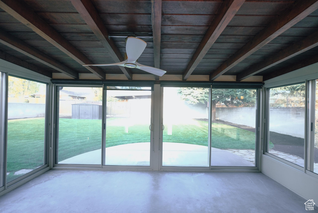 Unfurnished sunroom with beamed ceiling, wood ceiling, and ceiling fan