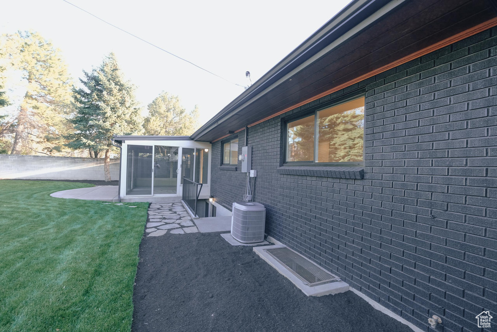 View of home\\\'s exterior with a yard and central air condition unit