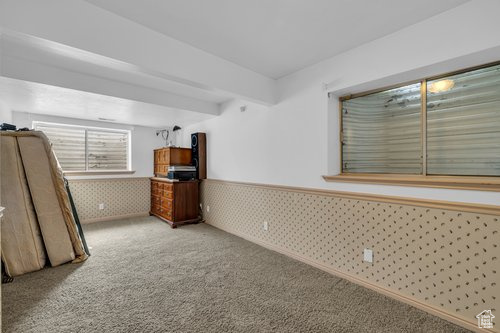 Unfurnished bedroom with beamed ceiling and carpet