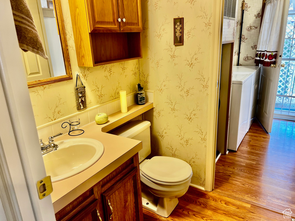Bathroom with wood-type flooring, vanity, washer / clothes dryer, and toilet