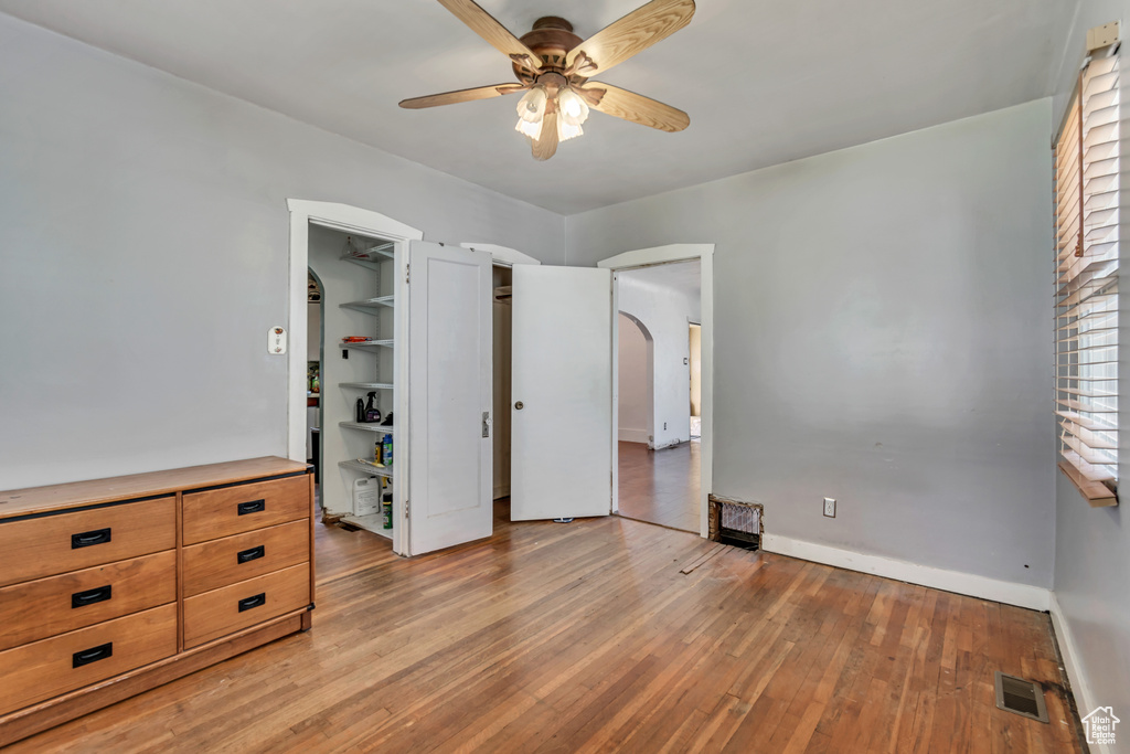 Unfurnished bedroom with a closet, light hardwood / wood-style floors, a spacious closet, and ceiling fan