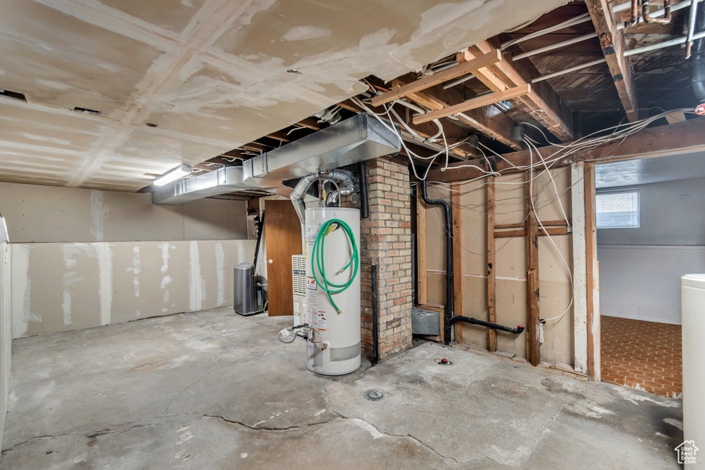 Basement featuring brick wall and gas water heater