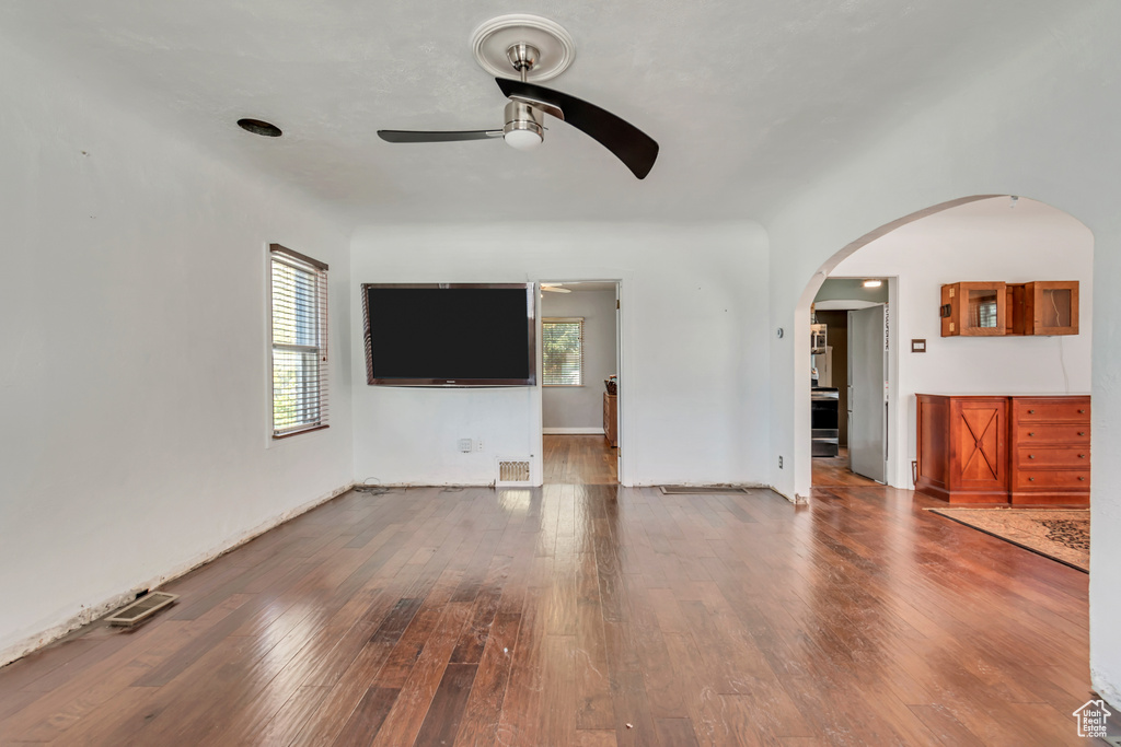 Unfurnished living room featuring ceiling fan and hardwood / wood-style flooring