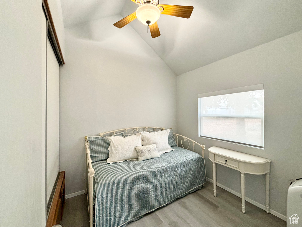 Bedroom featuring ceiling fan, hardwood / wood-style floors, and vaulted ceiling