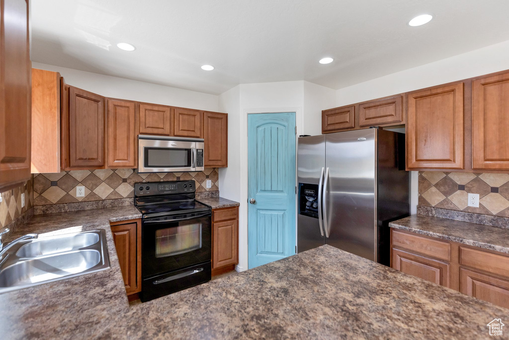 Kitchen featuring tasteful backsplash, appliances with stainless steel finishes, and sink
