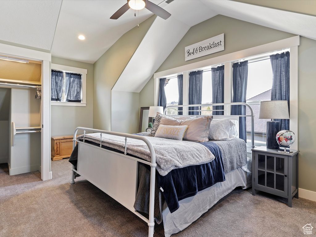 Bedroom with lofted ceiling, ceiling fan, and carpet