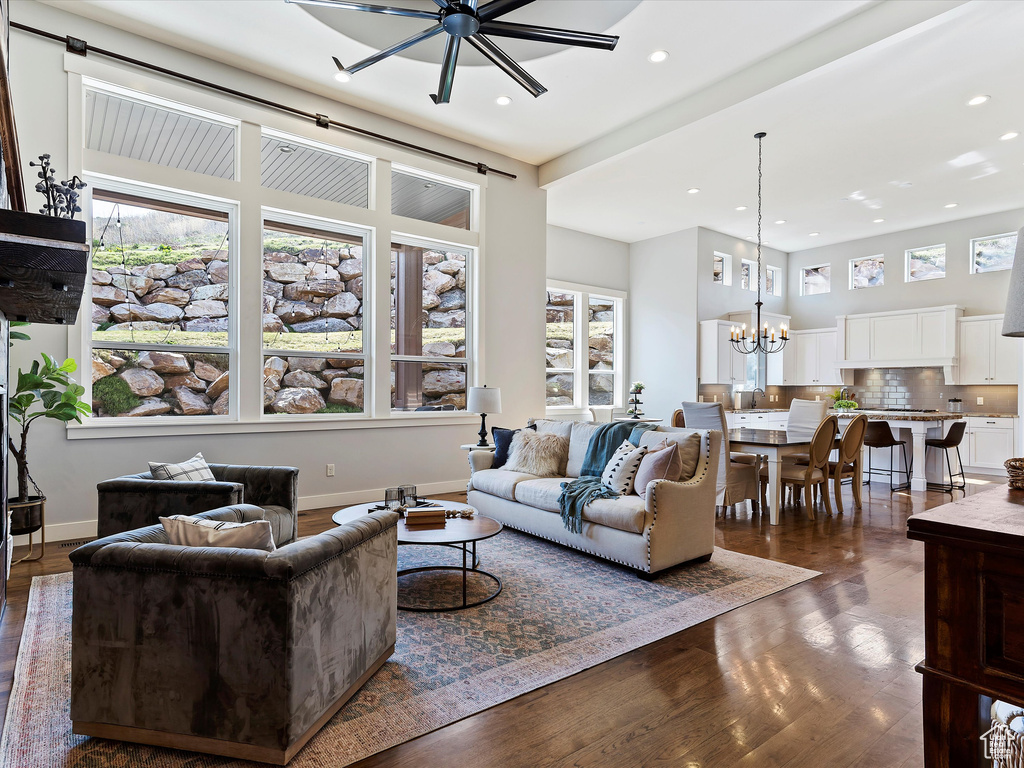 Living room featuring dark hardwood / wood-style flooring and ceiling fan with notable chandelier