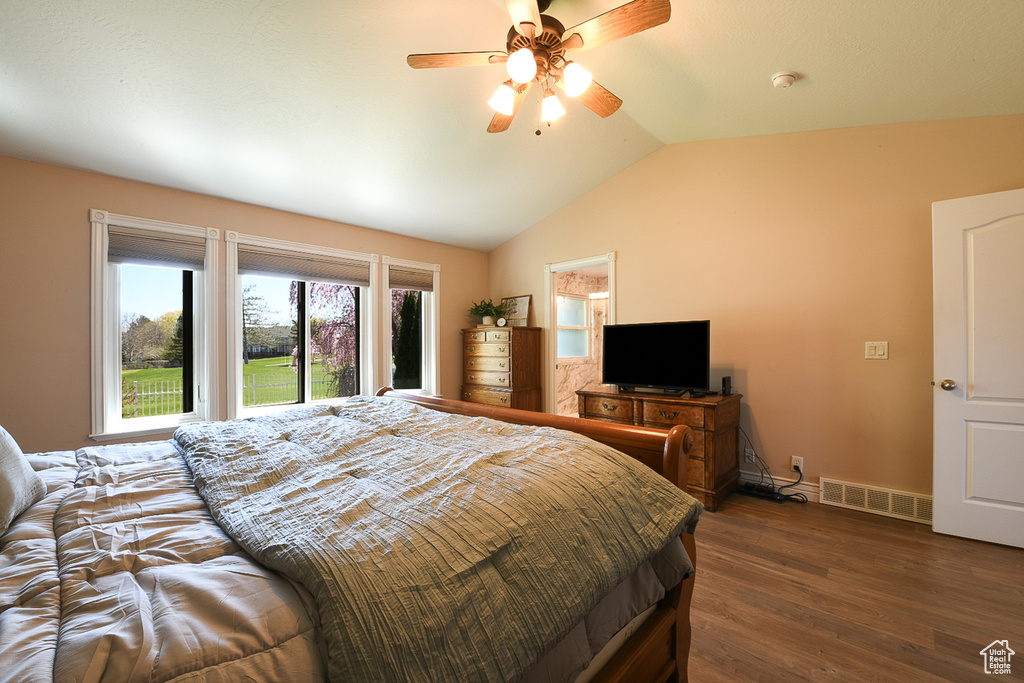 Bedroom featuring ceiling fan, dark hardwood / wood-style floors, and vaulted ceiling