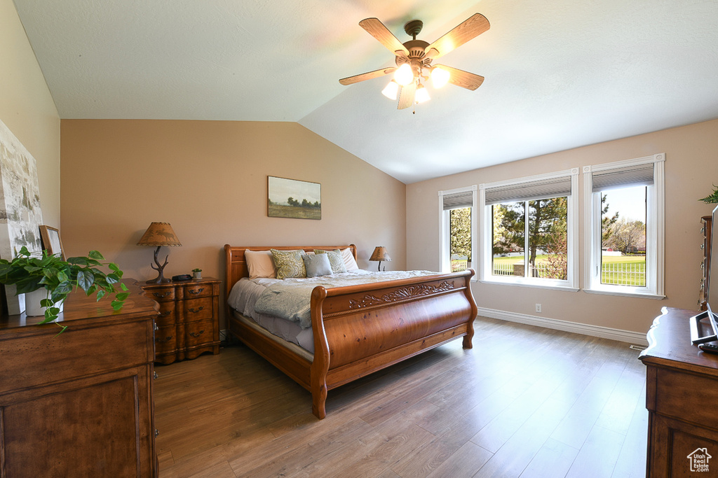 Bedroom with hardwood / wood-style floors, lofted ceiling, and ceiling fan