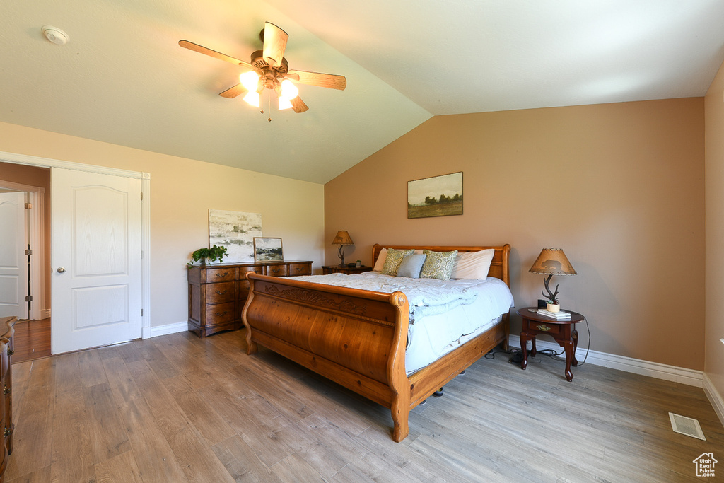 Bedroom with lofted ceiling, ceiling fan, and hardwood / wood-style flooring