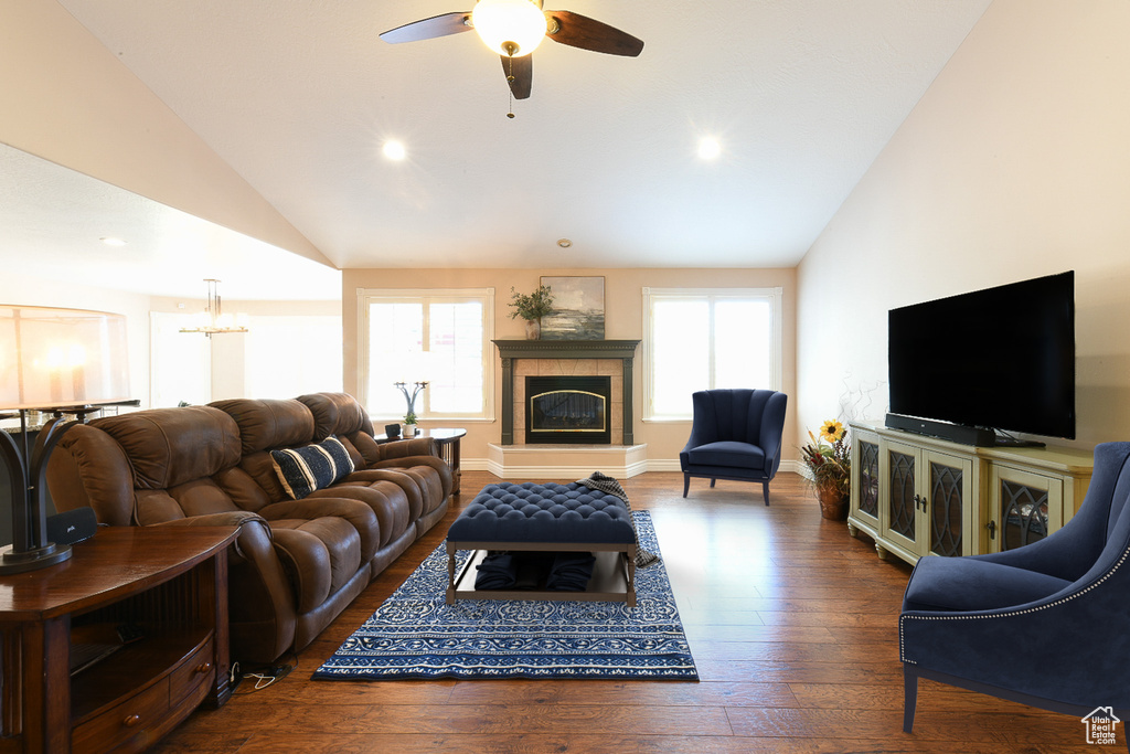 Living room with vaulted ceiling, dark hardwood / wood-style flooring, a healthy amount of sunlight, and a tile fireplace