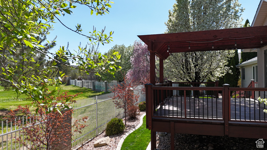 View of yard with a wooden deck and a pergola