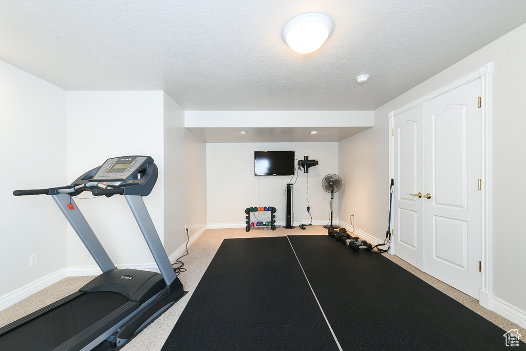 Exercise room featuring a textured ceiling and carpet floors