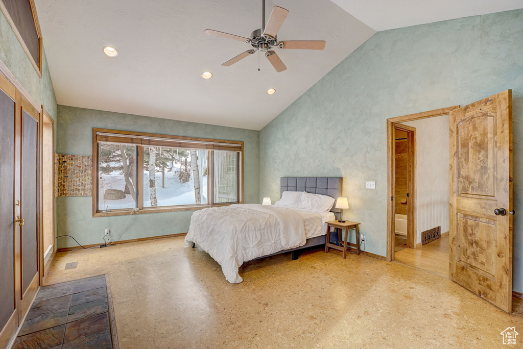 Bedroom featuring ensuite bath, light hardwood / wood-style floors, ceiling fan, and vaulted ceiling