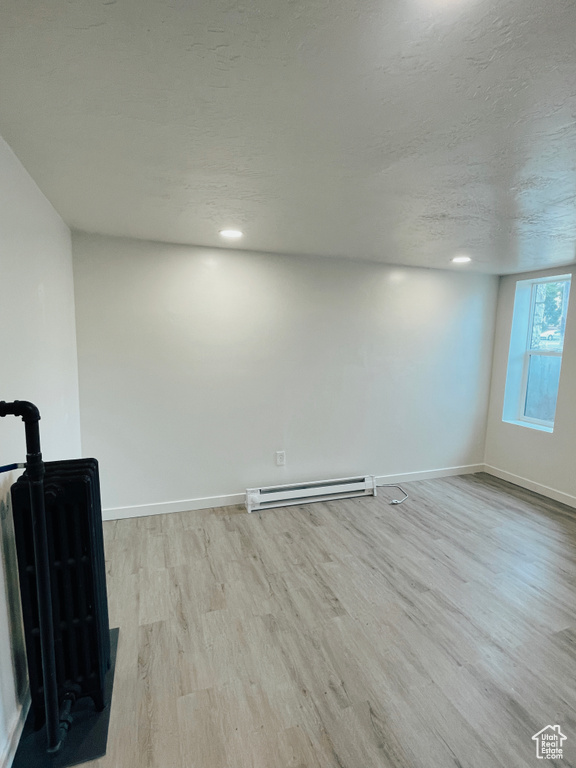 Interior space with light hardwood / wood-style flooring and a baseboard radiator