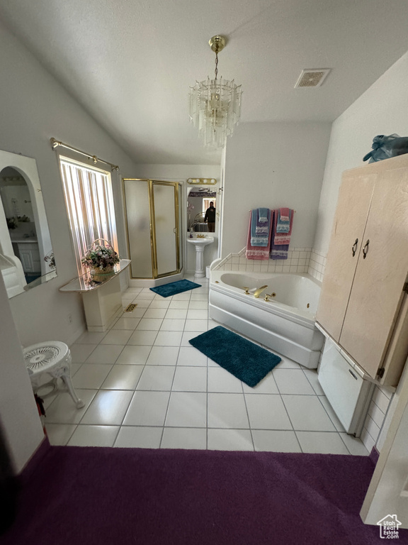 Bathroom with a washtub, a chandelier, and tile flooring