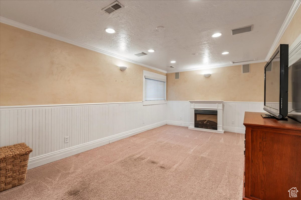 Unfurnished living room featuring crown molding, a textured ceiling, and carpet floors