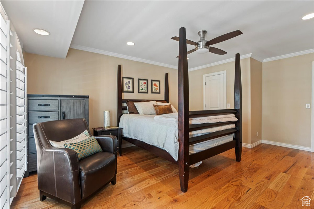 Bedroom with ornamental molding, ceiling fan, and light wood-type flooring