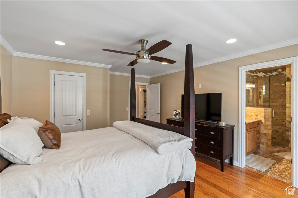 Bedroom with ensuite bath, ceiling fan, hardwood / wood-style flooring, and ornamental molding