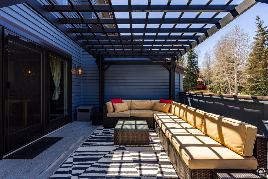 Wooden terrace featuring an outdoor living space and a pergola
