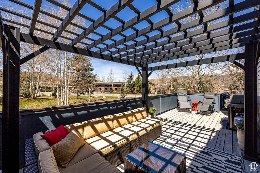 Deck with a pergola and outdoor lounge area