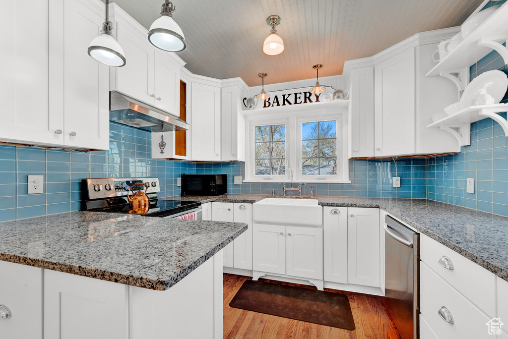 Kitchen with appliances with stainless steel finishes, backsplash, and hanging light fixtures