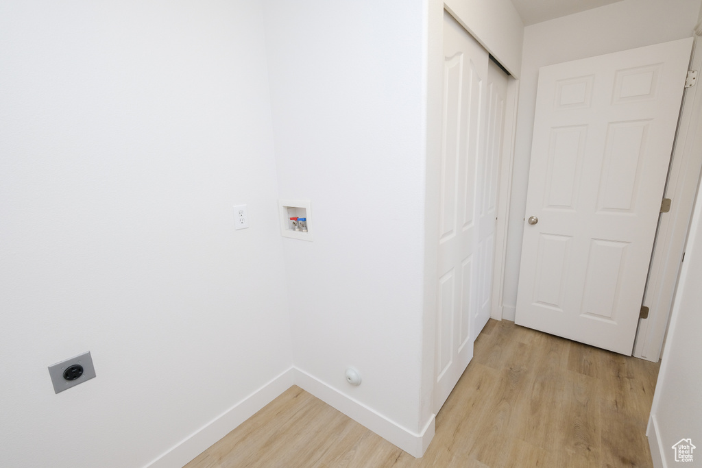 Laundry room with light hardwood / wood-style flooring, washer hookup, and electric dryer hookup