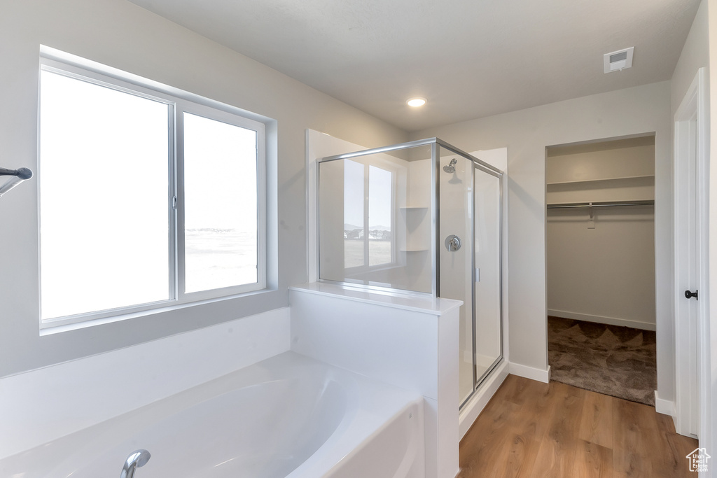 Bathroom featuring hardwood / wood-style flooring and separate shower and tub