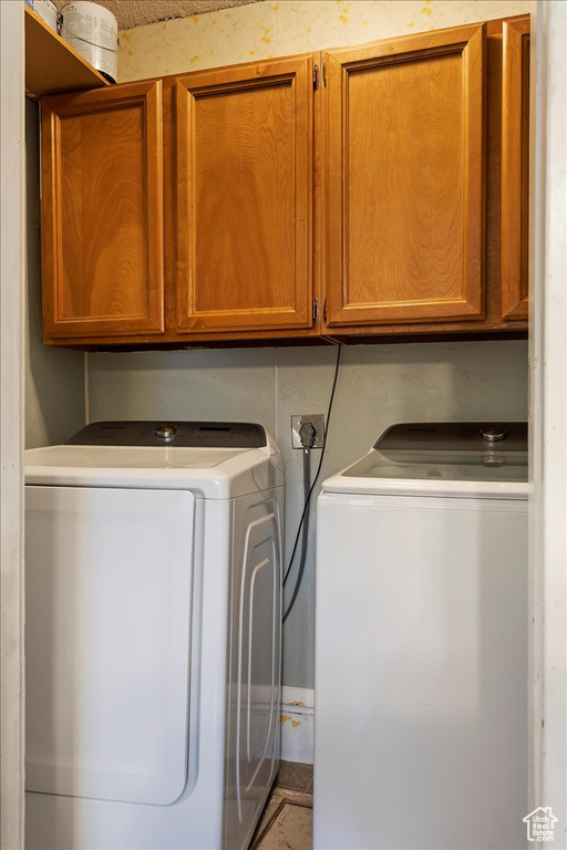 Laundry room featuring hookup for an electric dryer, washing machine and dryer, and cabinets