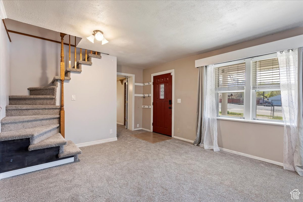 Foyer with carpet and a textured ceiling