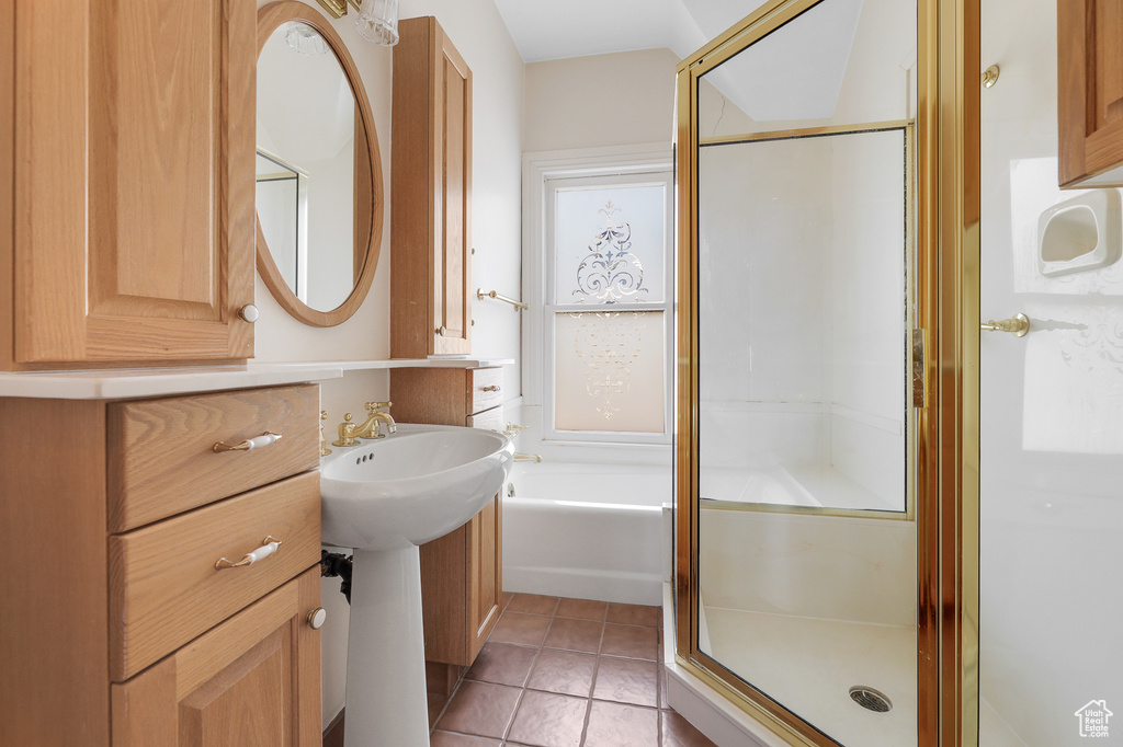 Bathroom featuring a shower with shower door and tile flooring