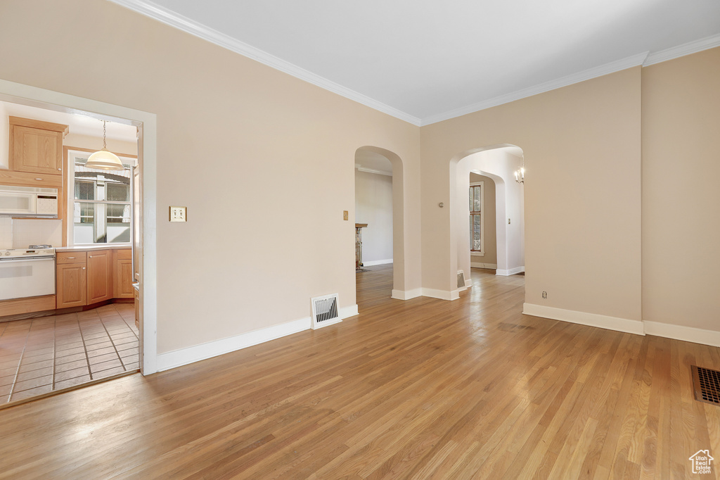 Unfurnished room featuring light wood-type flooring and ornamental molding