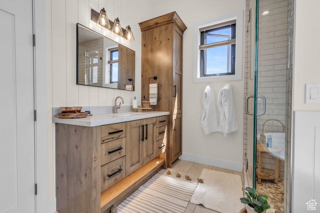 Bathroom with a shower with door, oversized vanity, and tile flooring