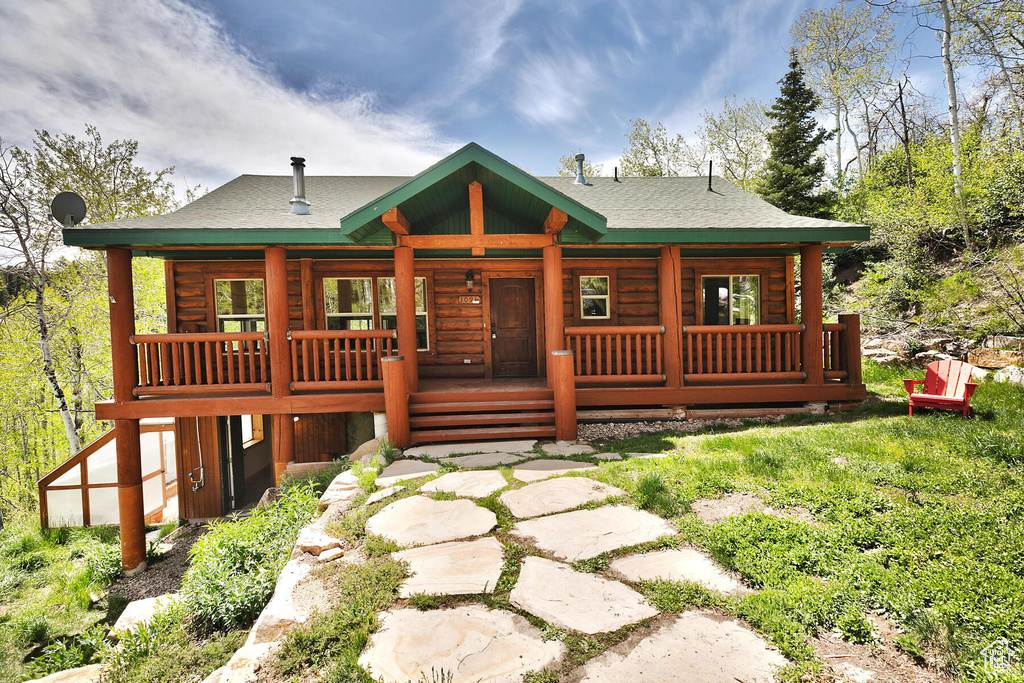 Log home featuring a porch