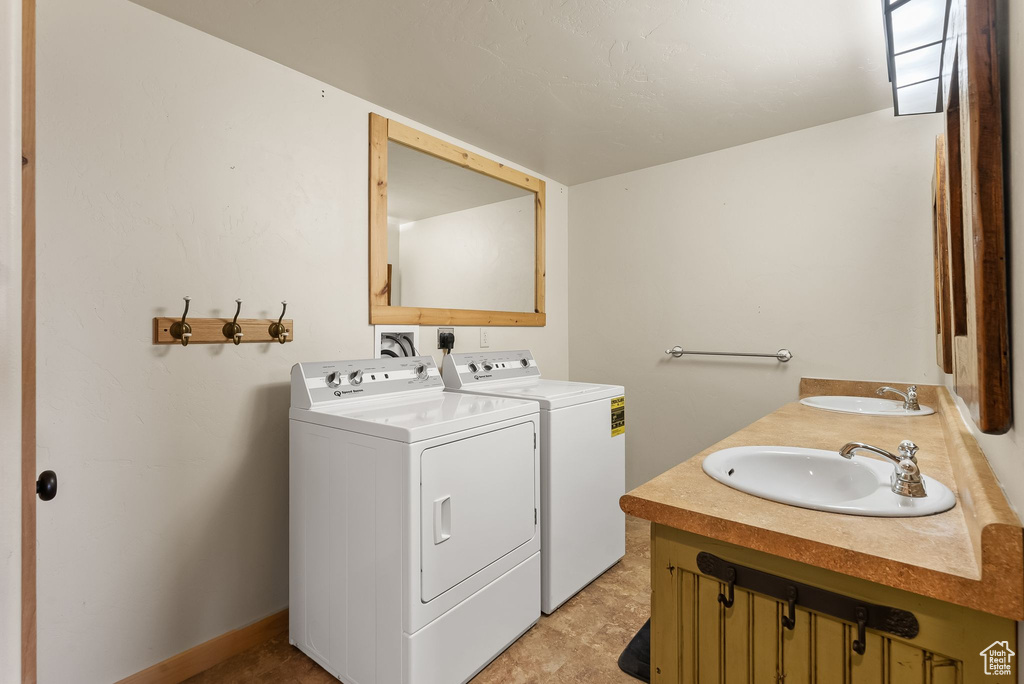 Washroom with sink, washing machine and dryer, light tile floors, and electric dryer hookup