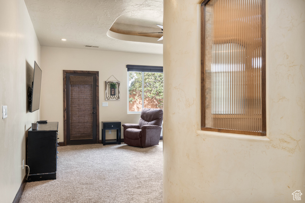 Interior space with a textured ceiling, carpet floors, and ceiling fan