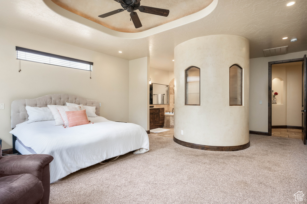 Bedroom featuring ensuite bath, ceiling fan, and carpet floors