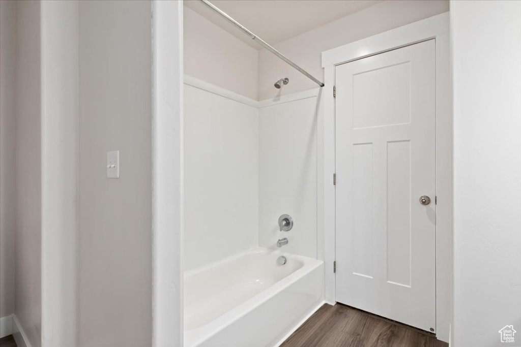 Bathroom with hardwood / wood-style floors and shower / tub combination